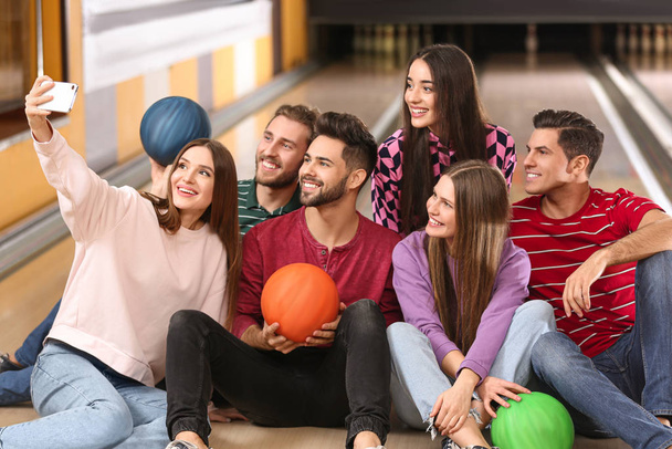 Group of friends taking selfie in bowling club - Фото, изображение
