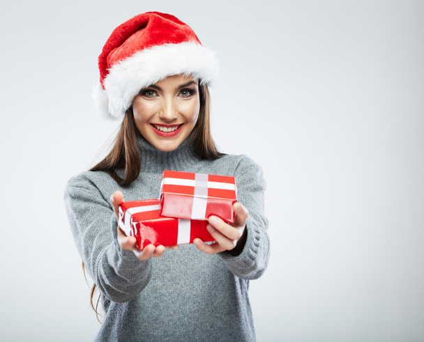 Portrait of woman in santa hat holding gift boxes - 写真・画像