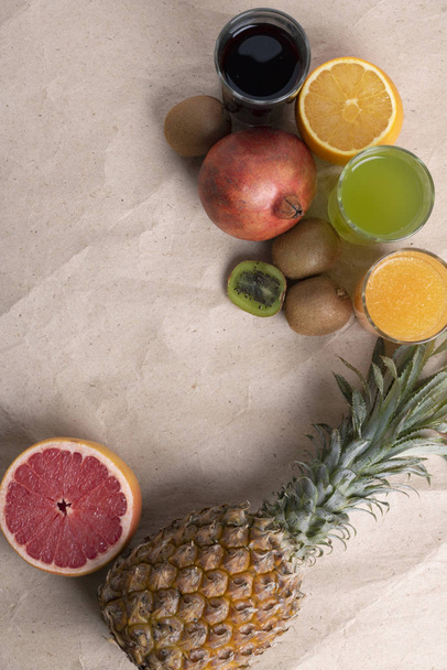 Frutti esotici su sfondo grigio. Frutti tropicali su carta ecologica, zero sprechi
 - Foto, immagini