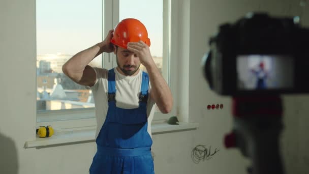 Zeitlupe, Bauarbeiter setzt Helm auf und spricht vor Kamera - Filmmaterial, Video