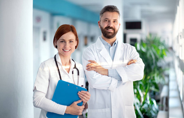 Um retrato de homem e mulher médico em pé no hospital
. - Foto, Imagem