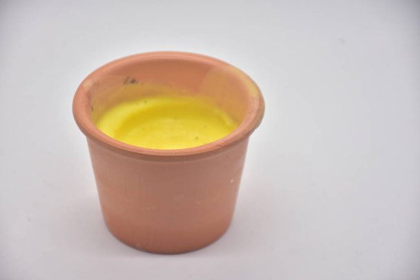 Closeup view of yellow smoothie in clay cup - Foto, imagen
