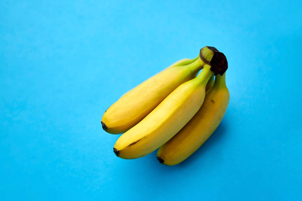close up of ripe banana bunch on blue background - 写真・画像
