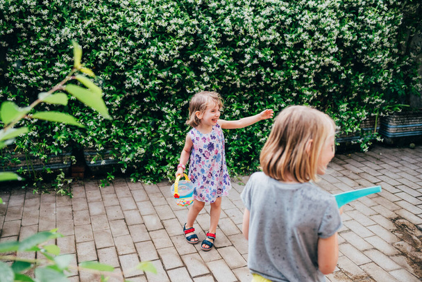 vrouwelijk kind outdoor spelen met emmer hebben plezier - Foto, afbeelding