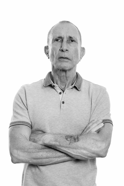 Studio shot of senior man isolated against white background in black and white - Фото, зображення