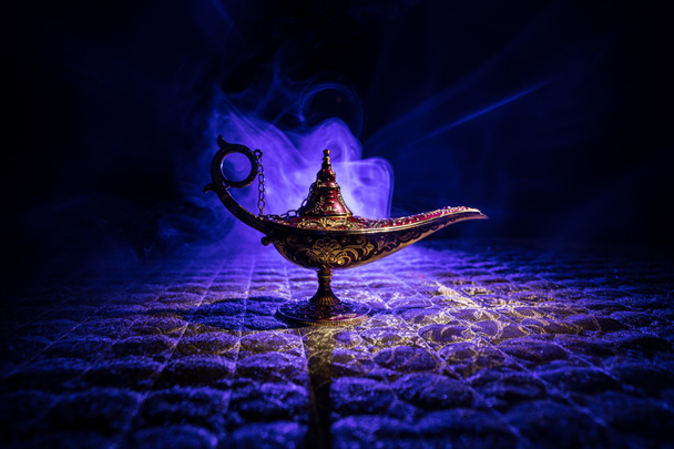 Antique Aladdin arabian nights genie style oil lamp with soft light white smoke, Dark background. Lamp of wishes concept - Photo, Image
