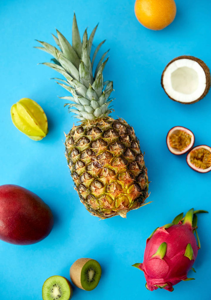 pineapple with other fruits on blue background - Foto, afbeelding