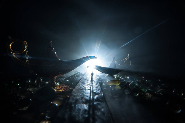 Концепция светильника желаний. Силуэт человека, стоящего посреди дороги в туманную ночь с гигантской античной арабианской лампой в стиле джинна. Творческое оформление произведений искусства
 - Фото, изображение
