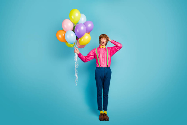 Full size photo astonished funky guy confuse day of festive pary celebration bring baloons touch head hands impressed scream omg wear good gentleman look shoes isolated blue color background - Foto, afbeelding