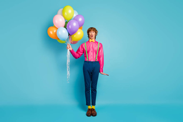 full length photo astonished guy hold many air baloons he receive get anniversary celebration party impressed scream wow omg wear good look clothing shoes isolated blue color background - Φωτογραφία, εικόνα