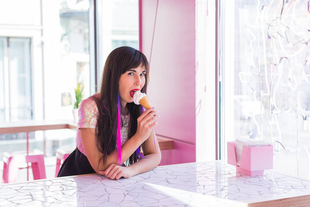 Summer, youth and dessert concept - Pretty girl enjoying an ice-cream cone in cafe - Fotó, kép