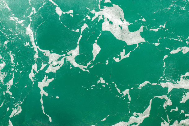 Türkiz tengervíz habbal. Absztrakt tengeri háttér. Óceánhullámok közelről. Lágy fókusz. - Fotó, kép