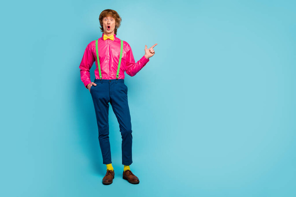 Full length photo astonished guy promoter point index finger copyspace look discounts adverts promotion impressed scream wow omg wear bright pink trousers isolated blue color background - Фото, зображення