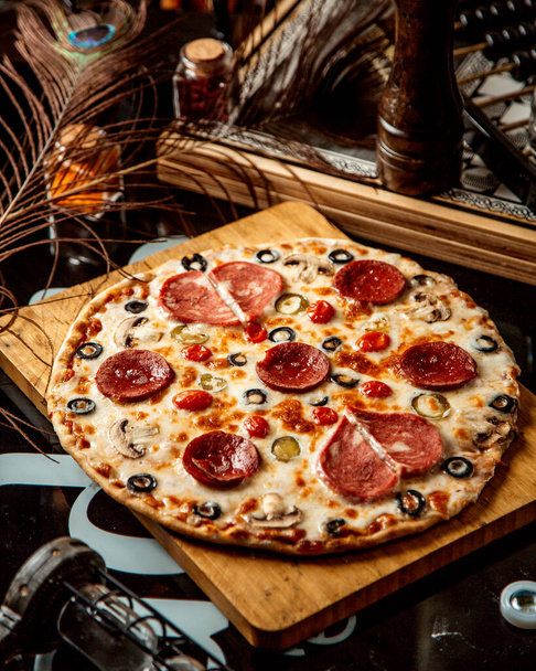 mixed pizza with sausages olives and tomato _ - Foto, imagen