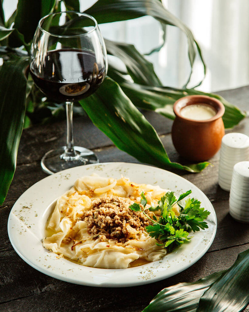 a plate of azerbaijani dish khangal square pasta served with minced meat and onion - Foto, Imagem