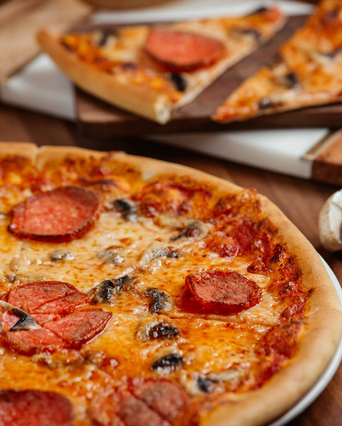 pizza met plakjes peperoni en champignons - Foto, afbeelding
