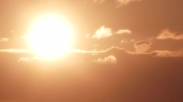 Κοντινό πλάνο στον λαμπερό ήλιο που λάμπει ακριβώς πάνω από τη γραμμή νεφών στον ζεστό φωτισμένο ουρανό. - Πλάνα, βίντεο