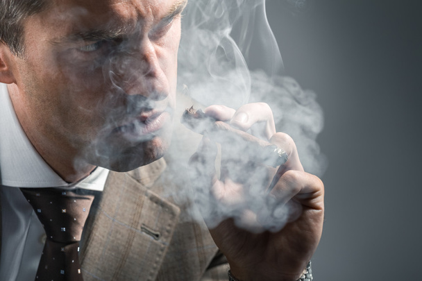 elegant adult man in a cloud of smoke - 写真・画像