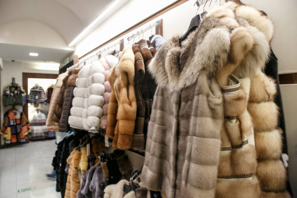 Doğal kürk mantolar bir mağazada askılarda asılı durur. Kışın sıcak tutacak giysi satışı. Türk dükkanı - Fotoğraf, Görsel