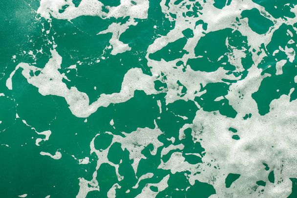 Água do mar azul-turquesa com espuma. Fundo marinho abstrato. Ondas oceânicas de perto. Foco suave
. - Foto, Imagem