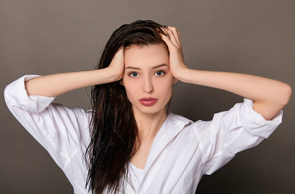 Charming Caucasian girl with wet hair in a white shirt. - Foto, Bild