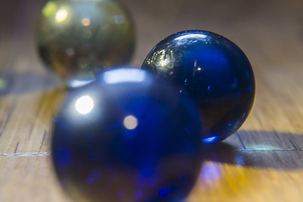 A closeup shot of a few marbles on top of a wooden table - Photo, image
