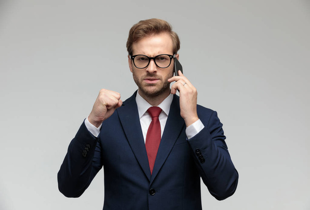 businessman talking on the phone and raising one fist up - Photo, Image