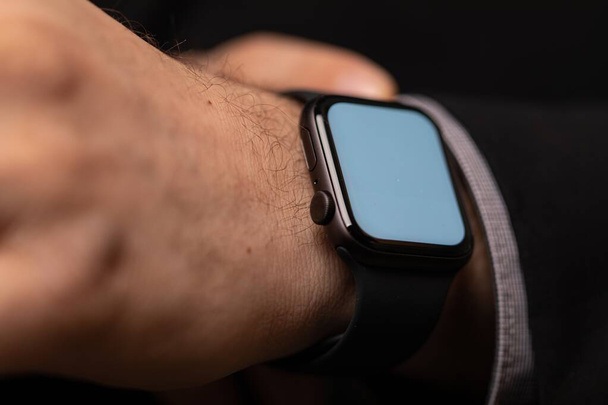 A closeup shot of a smartwatch tied on a man's hands - Foto, Imagem