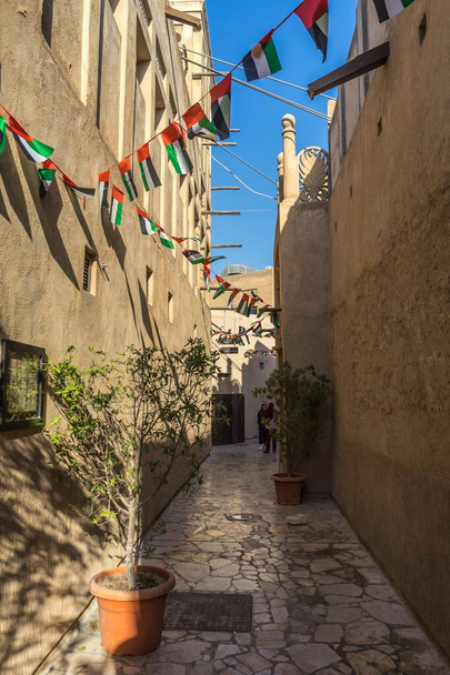 The Al Fahidi Historical Neighbourhood surrounded by flags under the sunlight in UAE - Foto, Imagem