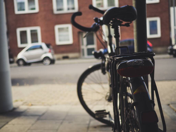 A closeup shot of a black bicycle next to a building - Foto, immagini