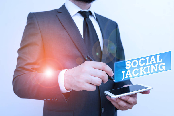 Text sign showing Social Jacking. Conceptual photo Spiteful method tricking the user to click vulnerable buttons Male human wear formal work suit hold smart hi tech smartphone use one hand. - Foto, afbeelding