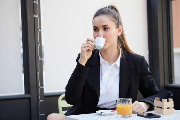 young businesswoman talking to mobile and drink a cup of coffee - Foto, Imagen