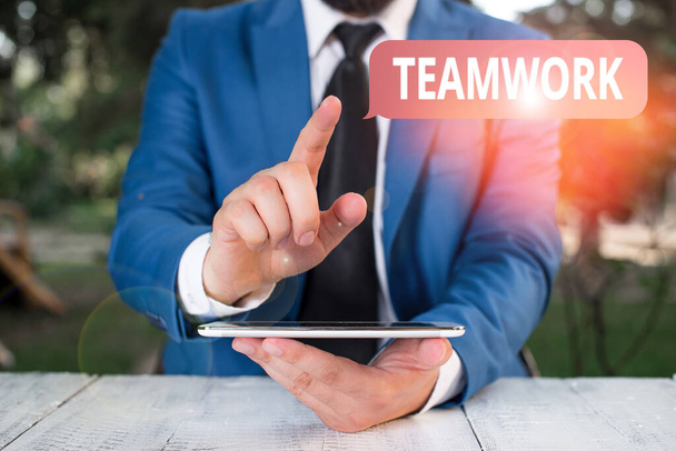 Writing note showing Teamwork. Business photo showcasing combined action of group especially when effective and efficient Businessman with pointing finger in front of him. - Foto, Imagem
