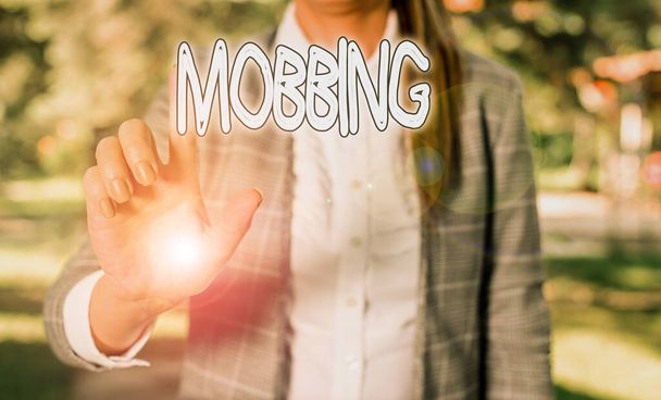 Word writing text Mobbing. Business concept for Bulling of individual specially at work Emotional abuse Stress Business woman in the nature pointing with the finger into empty space. - Photo, Image