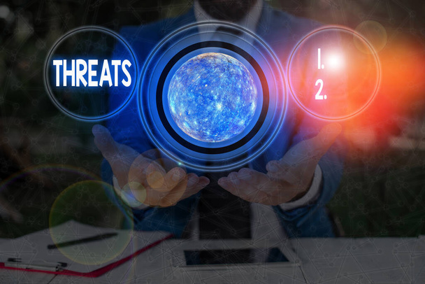 Text sign showing Threats. Conceptual photo Statement of an intention to inflict pain hostile action on someone Elements of this image furnished by NASA. - Photo, Image
