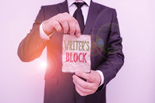 Handwriting text Writer S Is Block. Concept meaning condition of being unable to make a piece of written work Male human wear formal work suit office look hold notepaper sheet use hand. - Photo, Image