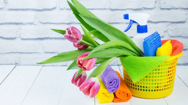 Frühjahrsputz-Urlaubskonzept, Vorräte und Werkzeuge zum Putzen und Frühlingsblumen. Flüssige Desinfektionsmittel, Schwämme und Reinigungstücher. Kopierraum - Foto, Bild