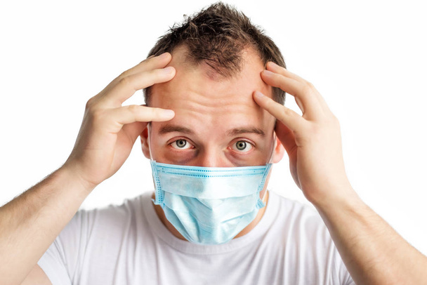 顔に青い医療マスクの頭の近くの手で恐ろしい病気の原因となるアジア人の男性の水平接近肖像画、コロナウイルスを恐れている。寒い季節に健康管理。略称は2019年。医療. - 写真・画像
