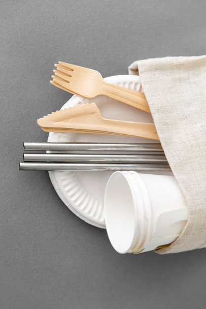 wooden forks, knives and paper cups on plate - Fotoğraf, Görsel