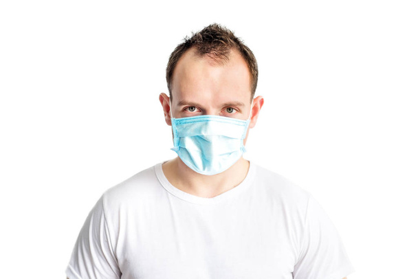 Portrait of serious and self confident caucasian man in blue medical mask on face. Health care in cold season. Prevention of coronavirus covid-2019. Stop coronavirus. Medical and health care. - Foto, imagen