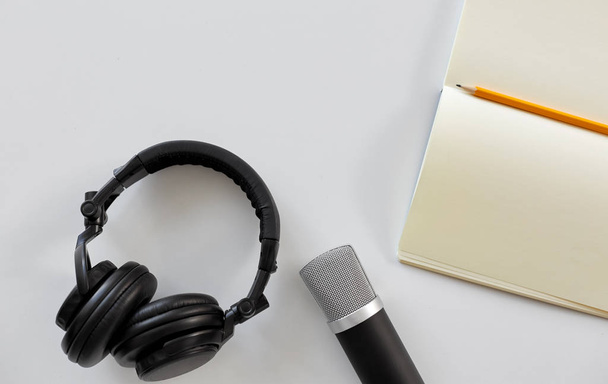 headphones, microphone and notebook with pencil - Photo, image
