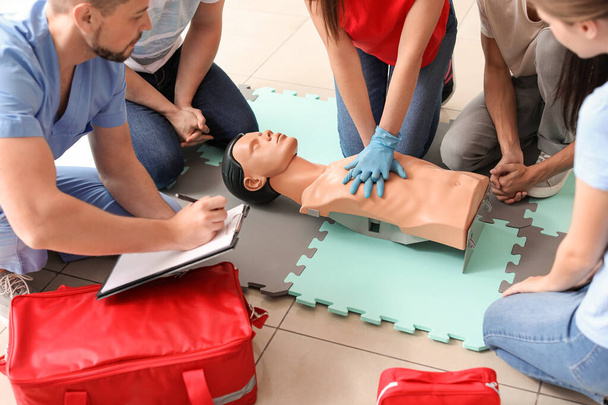 Ausbilder demonstriert bei Erste-Hilfe-Lehrgang CPR an Schaufensterpuppe - Foto, Bild
