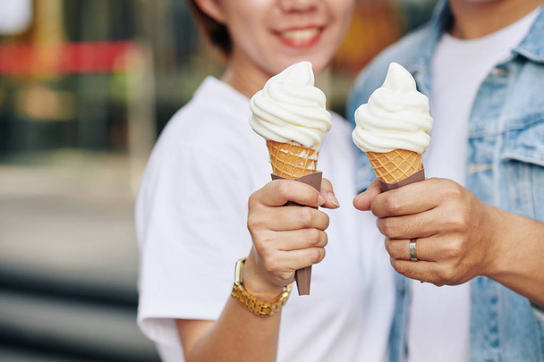Nerozpoznatelný pár na rande drží chutné zmrzliny kužely v rukou, horizontální zblízka záběr - Fotografie, Obrázek