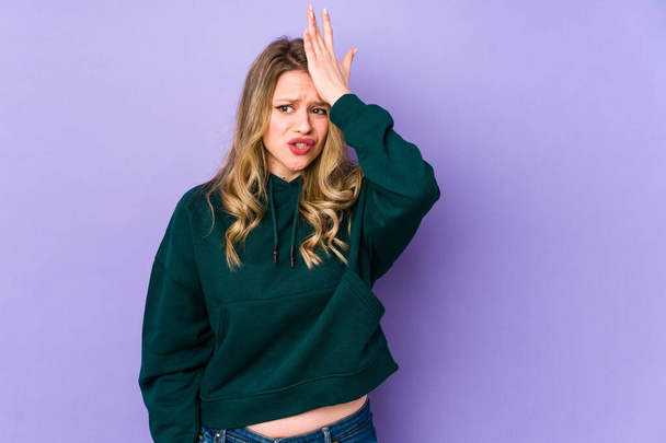 Young caucasian woman isolated on purple background forgetting something, slapping forehead with palm and closing eyes. - Photo, Image
