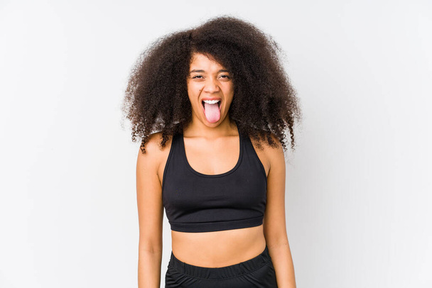 Молода афроамериканська спортивна жінка смішна і привітна, що витискає язик.. - Фото, зображення
