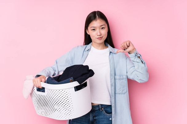 Junge Chinesin sammelt schmutzige Kleidung isoliert fühlt sich stolz und selbstbewusst, Beispiel zu folgen. - Foto, Bild