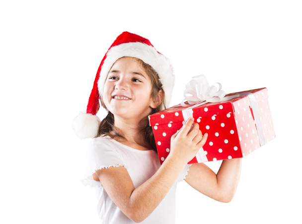 Small girl in santa hat with christmas gift - 写真・画像