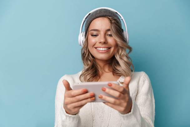 Portrait of cute joyful woman using headphones and cellphone - Foto, immagini