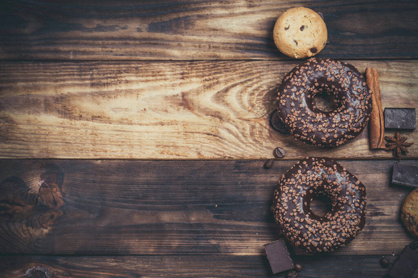 Chocolate donut and chocolate on a wooden table in warm color - Photo, image