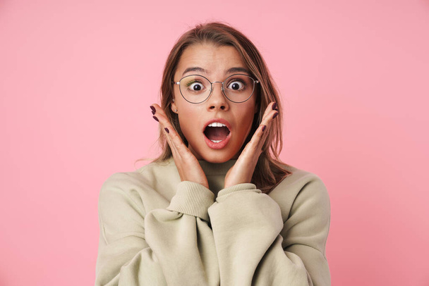 Portrait of beautiful shocked woman in eyeglasses looking at camera - Photo, image
